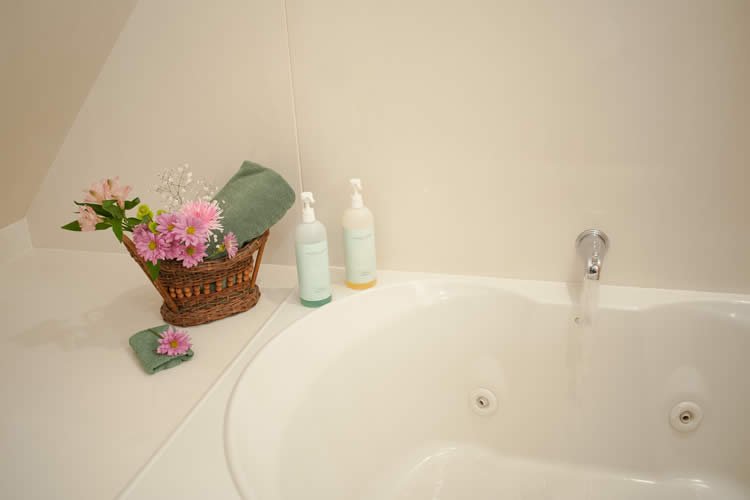 Jetted tub with a basket with pink flowers