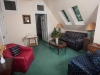 Sitting area, navy blue striped couch, burgundy chair, blue chair