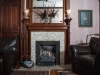 LIving room with Gas fireplace with tile around then hand carved mantel and outline