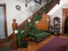 Foyer with Green love seat  grand staircase with carved wood and hardwood floors